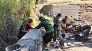 Personel TNI bersama masyarakat bergotong royong mengerjakan pembangunan Jembatan Beton Tahap VI di salah satu lokasi pembangunan di Kabupaten Gowa, Sulawesi Selatan.