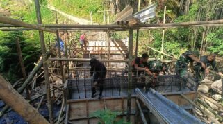 Personel TNI bersama warga Desa Pao, Kecamatan Tombolo Pao, Kabupaten Gowa, bergotong royong membangun Jembatan Beton Tahap VI di Sungai Ere Pucca’, Sabtu (22/8/2026).