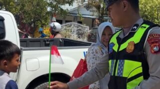 Sat Lantas Polres Polewali Mandar (Polman) membagikan bendera Merah Putih kepada pelajar di SDN 066 Pekkabata, Kecamatan Polewali, Minggu (16/8/2026). (Foto: Ist)
