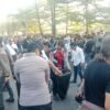 Peserta unjuk rasa bersama personel Polresta Gowa membersihkan sampah yang berserakan di depan Kantor Bupati Gowa setelah aksi penyampaian aspirasi berakhir, Jumat (28/8/2026) sore. (Foto: RujukanNews)