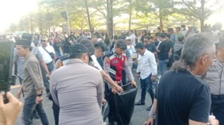 Peserta unjuk rasa bersama personel Polresta Gowa membersihkan sampah yang berserakan di depan Kantor Bupati Gowa setelah aksi penyampaian aspirasi berakhir, Jumat (28/8/2026) sore. (Foto: RujukanNews)